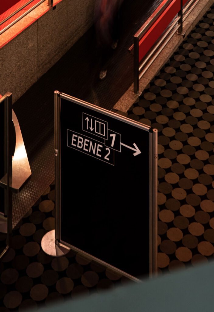 View from above on the signpost for level information. People in motion in the background