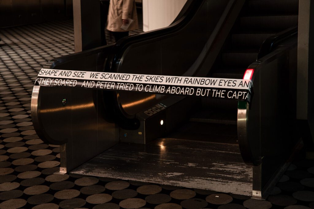 Locked escalator with writing on tape. Dark surroundings