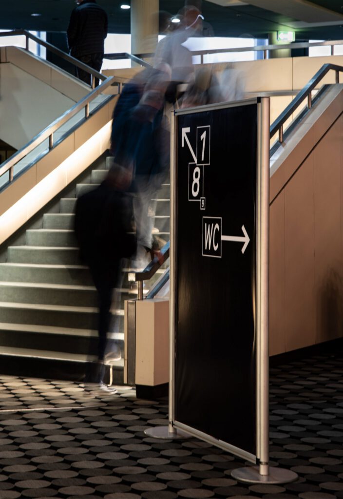 In front of the staircase is an exhibitor pointing the way. This is black and white and shows the floors and WC