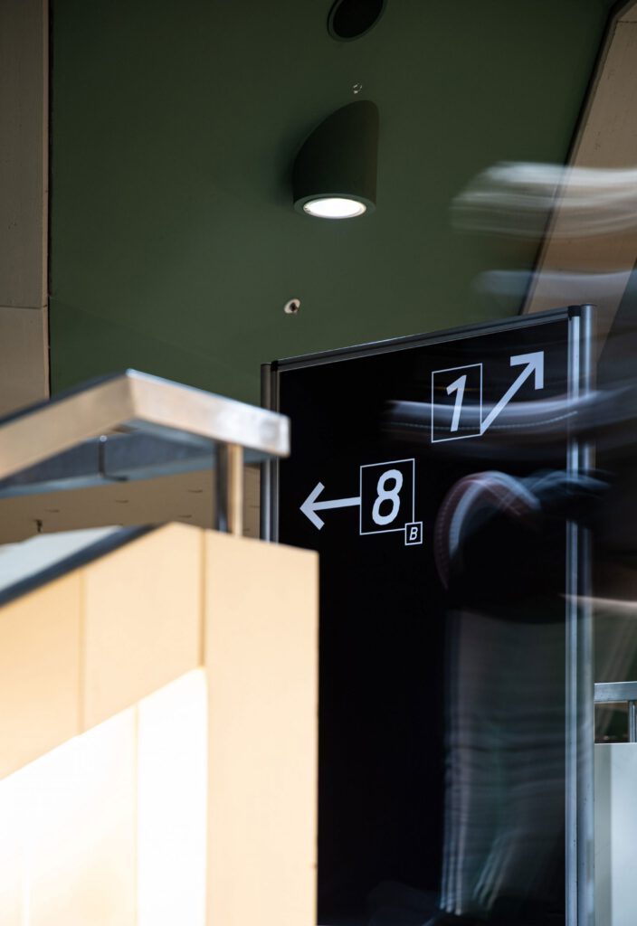 Behind a railing you can see an exhibitor pointing the way. This is black and white and shows numbers