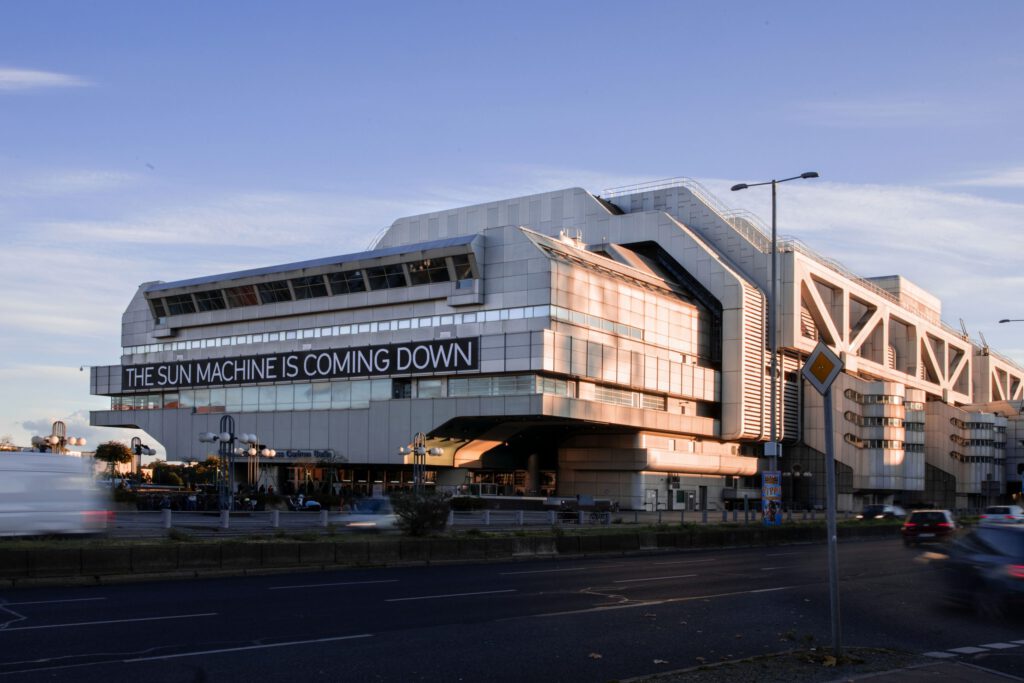 Picture of a large building at dusk with a bold caption saying 