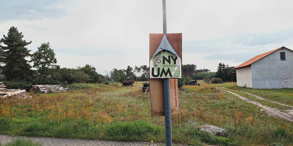 Photo of a rural property where a damaged poster hangs on a pole